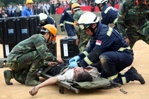Bộ đội Công binh Việt Nam và lực lượng cứu hộ cứu nạn của nước bạn đưa người bị nạn lên cáng...